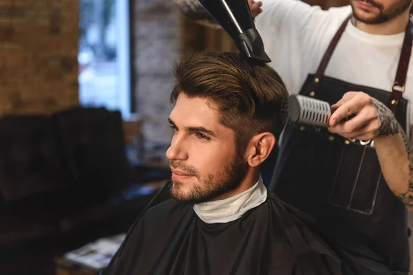 Estilista com secador de cabelo e pente — Fotografia de Stock