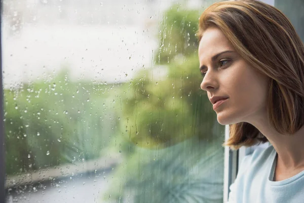 Eenzaam meisje kijkend naar regen — Stockfoto