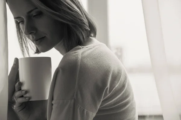 Грустная девушка пьет кофе — стоковое фото