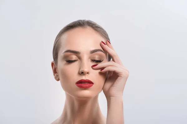 Ung kvinna med röda läppar och naglar i studio — Stockfoto