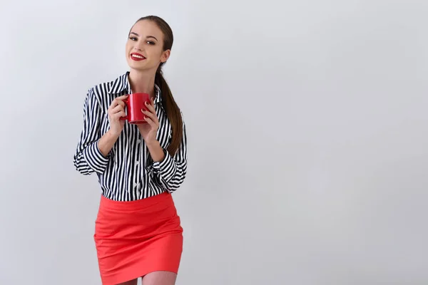 Jovem mulher desfrutando xícara de café no estúdio — Fotografia de Stock