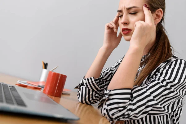 Ung affärskvinna arbetar på skrivbord i studio — Stockfoto