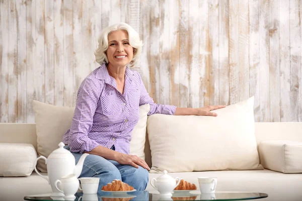 Joyful old lady resting on couch — Stock Photo, Image