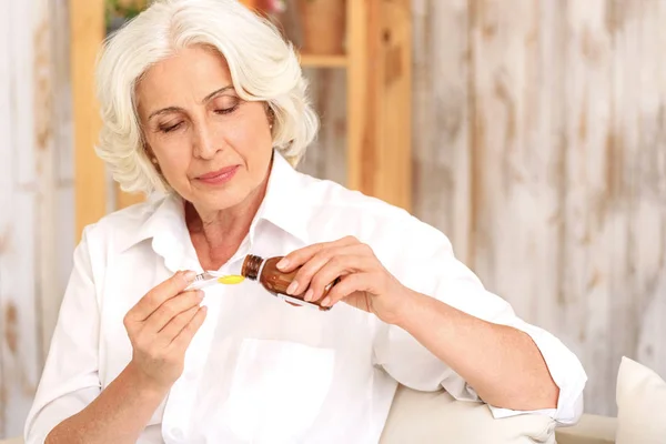 Sick old woman preparing medication against cough — Stock Photo, Image