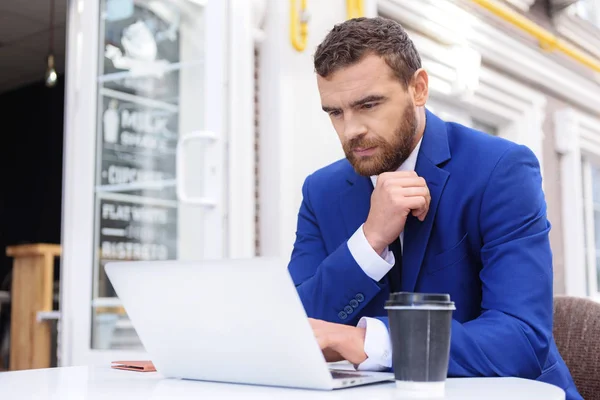 Cara de terno sentado na frente do laptop — Fotografia de Stock