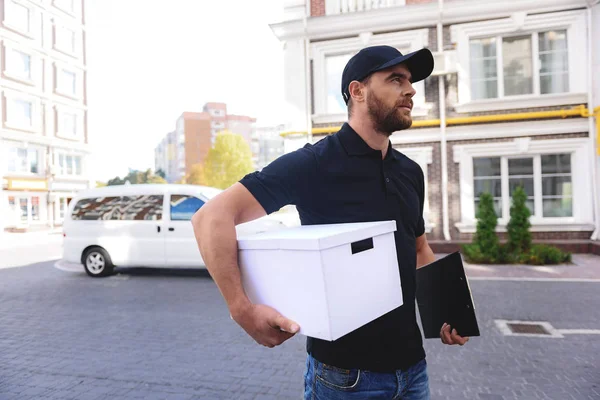 Happy bearded postman goes to clients home — Stock Photo, Image
