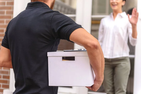 Courrier levererar en låda till den lycklig kvinnan — Stockfoto