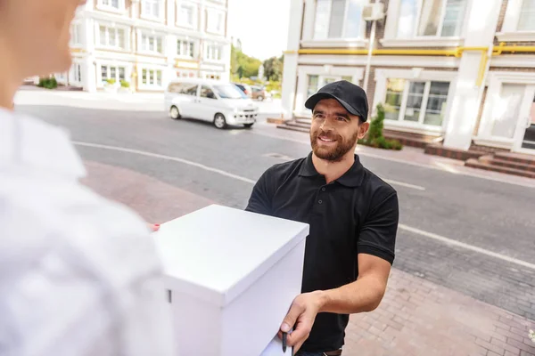 Courier ger ett paket till kvinna — Stockfoto