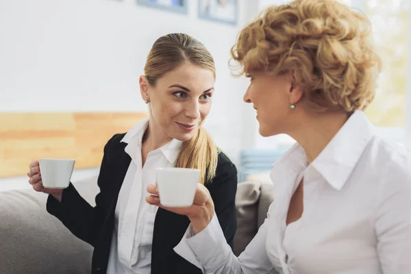 Дві бізнес-леді розмовляють в офісному залі — стокове фото