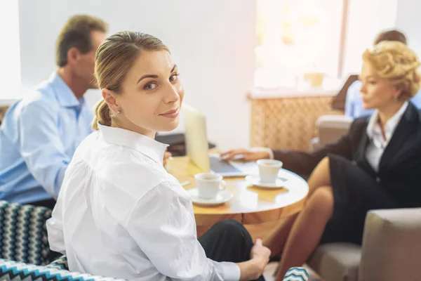 Ontspannen business team samen aan tafel zit — Stockfoto