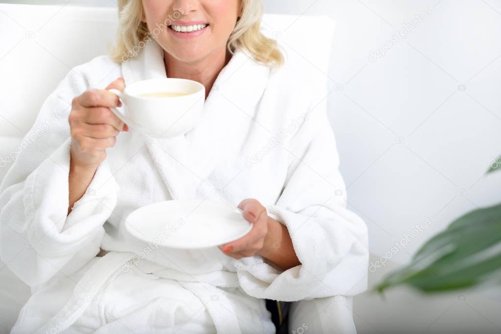 Mature lady enjoying healthy drink at spa