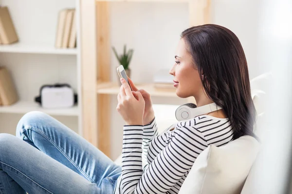 Sorglose Frau mit Handy zu Hause — Stockfoto