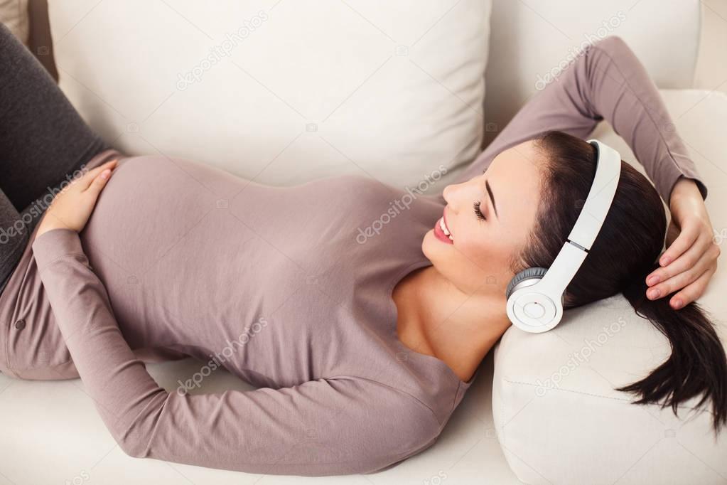 Joyful expectant mother enjoying melody