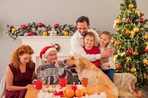 Parents and kids celebrating Christmas with pet — Stock Photo, Image