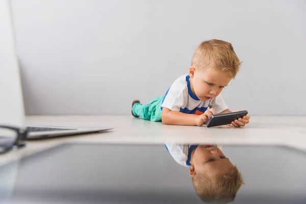 Niño pequeño con aparatos digitales en el estudio — Foto de Stock