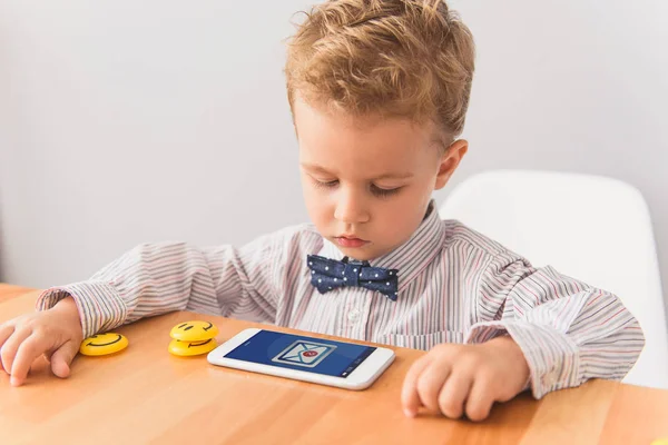 Menino sentado à mesa no estúdio — Fotografia de Stock