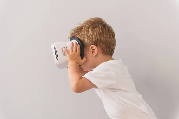 Маленький хлопчик використовує пристрій віртуальної реальності в студії — стокове фото