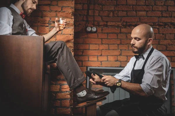 Klienten som vilar med drycker medan hans skor är vaxad — Stockfoto