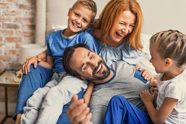 Liggend op bed thuis en gelukkige familie — Stockfoto