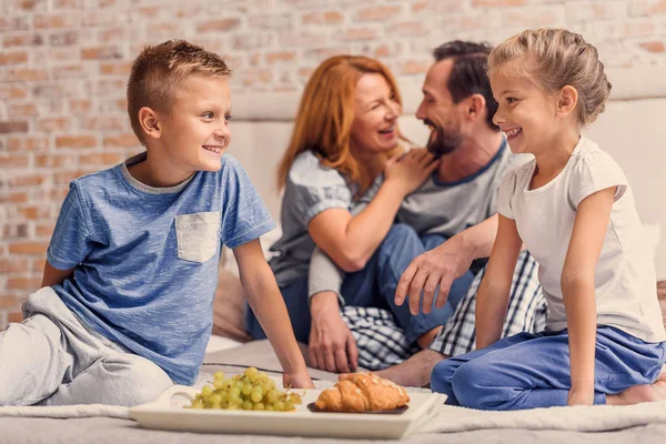 Liggend op bed thuis en gelukkige familie — Stockfoto