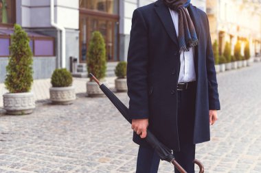 Caddede bekleyen takım elbiseli adam