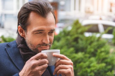 Mutlu adam açık havada sıcak içecek içme