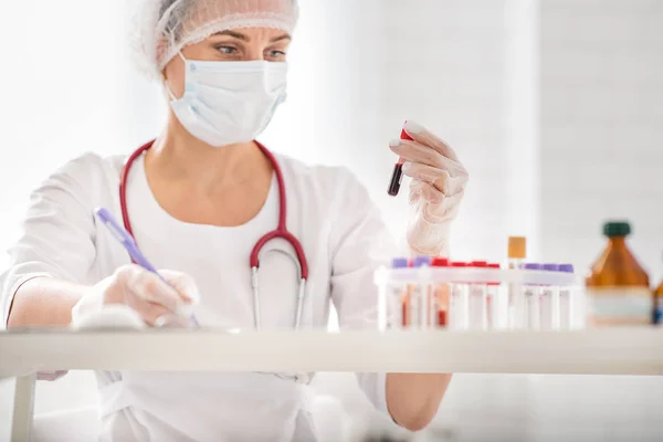 Médico ocupado examinando tubos de ensayo — Foto de Stock