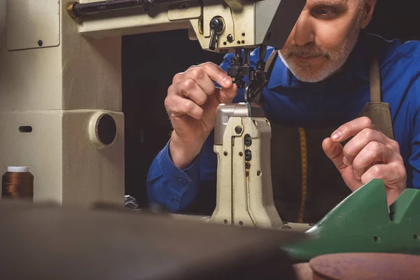 Man preparing the tailoring machine for work — Stock Photo, Image