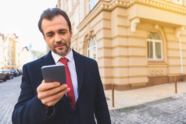 Uomo impegnato con smartphone sulla strada — Foto Stock