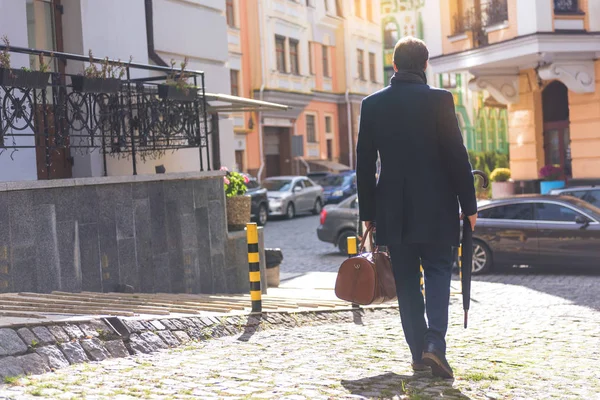 Businessman walking in city with briefcase