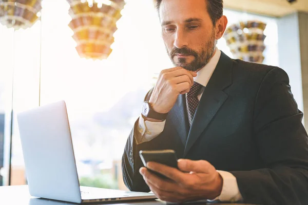 Uomo serio utilizzando smartphone in caffè — Foto Stock