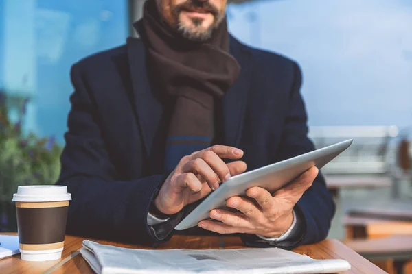 Rijpe zakenman met behulp van technologie in cafetaria — Stockfoto