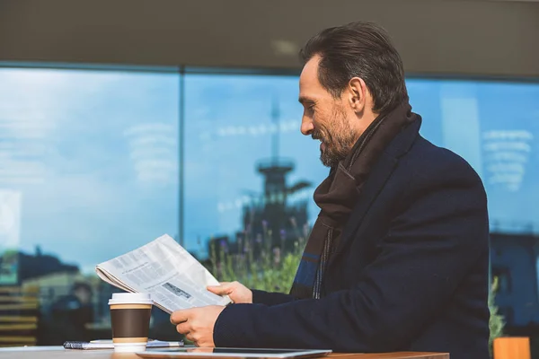Hombre de negocios de mediana edad leyendo el periódico en la cafetería — Foto de Stock