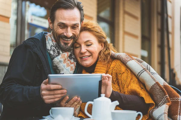 Loving couple using gadget in cafeteria — Stock Photo, Image