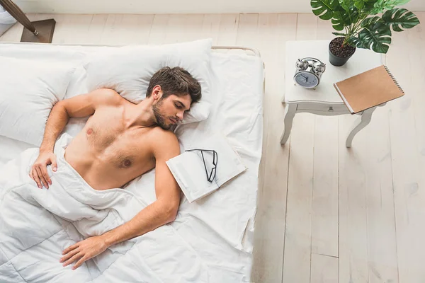 Красивый мужчина дремлет в спальне — стоковое фото