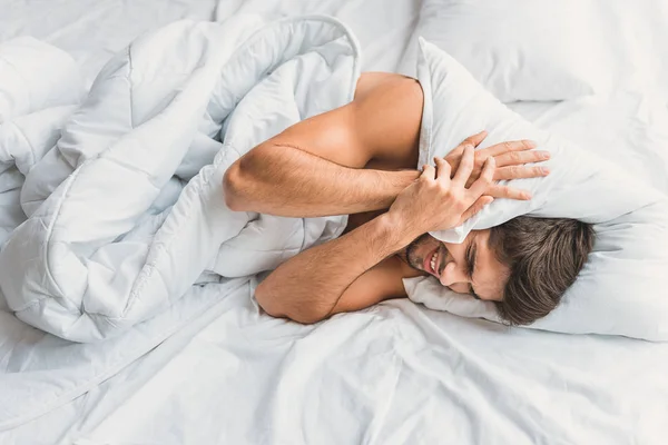 Guy is te drukken op down kussen met beide handen — Stockfoto