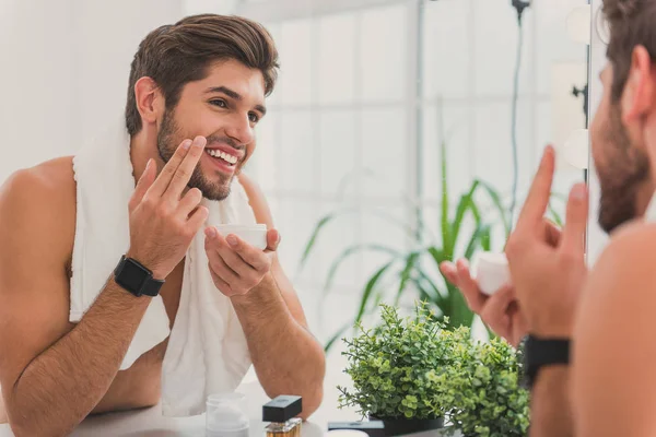 Cheerful beaded guy caring of his skin — Stock Photo, Image