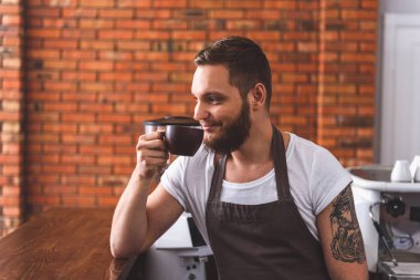 Mutlu adam Latte kahve dükkanında içinde zevk
