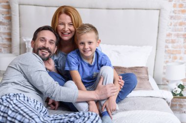 birlikte yatağa oturan aile