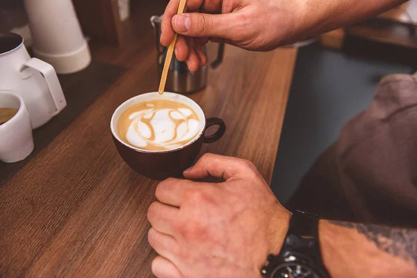 Jovem barman criando imagem em xícara de latte — Fotografia de Stock