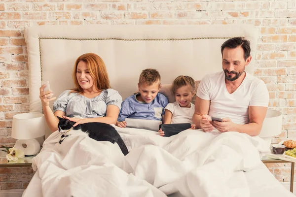 Familia disfrutando de gadgets en casa —  Fotos de Stock