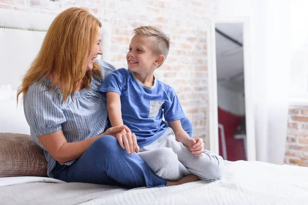 Adulto mamá y el hijo se divierten en el dormitorio —  Fotos de Stock