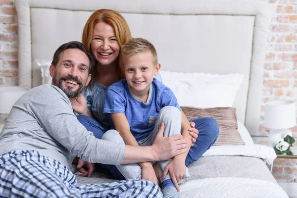 Familie zitten samen op bed — Stockfoto