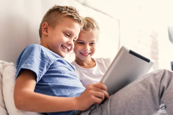 Niños disfrutando de gadget digital en el dormitorio — Foto de Stock