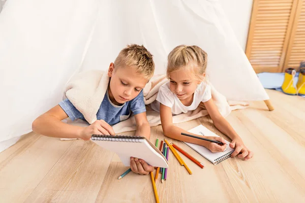 Little children fond of painting at home