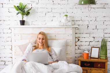 Bilgisayar yatakta rahat kızla