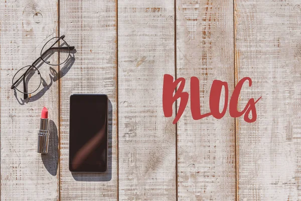 Smartphone and eyeglasses on desk for female blogger — Stock Photo, Image