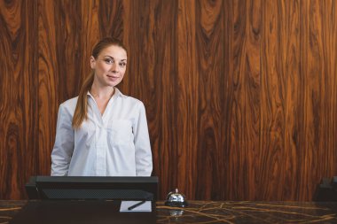 Kadın resepsiyonist tezgahın arkasında poz
