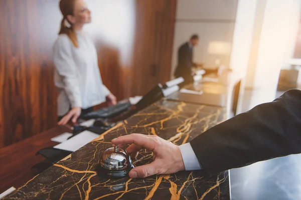 Homem usando o sino do hotel na recepção — Fotografia de Stock