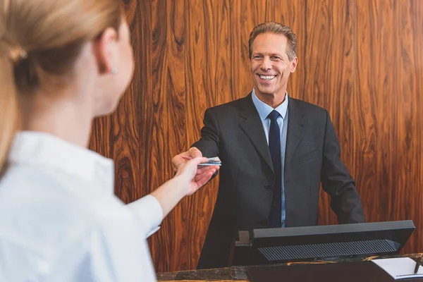 Gerente de hotel sonriente bienvenida mujer — Foto de Stock